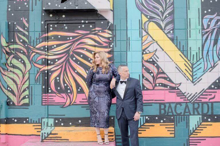 A newlywed couple stands in front of wall art