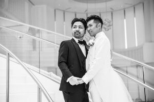 A couple on their wedding day pose on a long, sweeping staircase