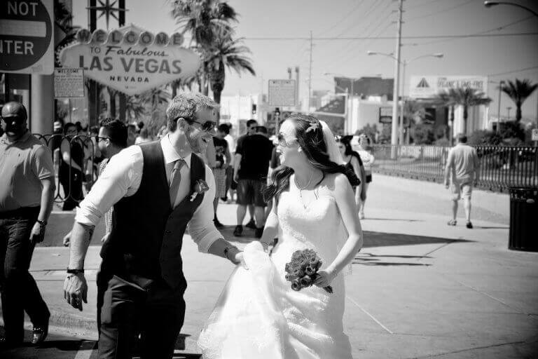 A bride and groom in black and white with Las Vegas sign in the background