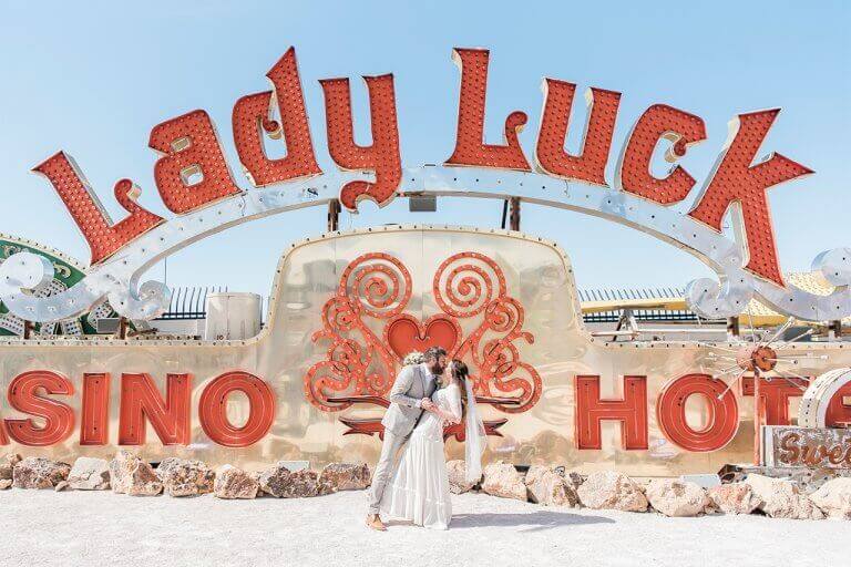 Newlyweds kissing on their wedding day in front of the Lady Luck Casino