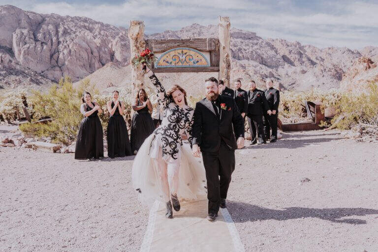 Wedding couple walking down ghost town desert aisle