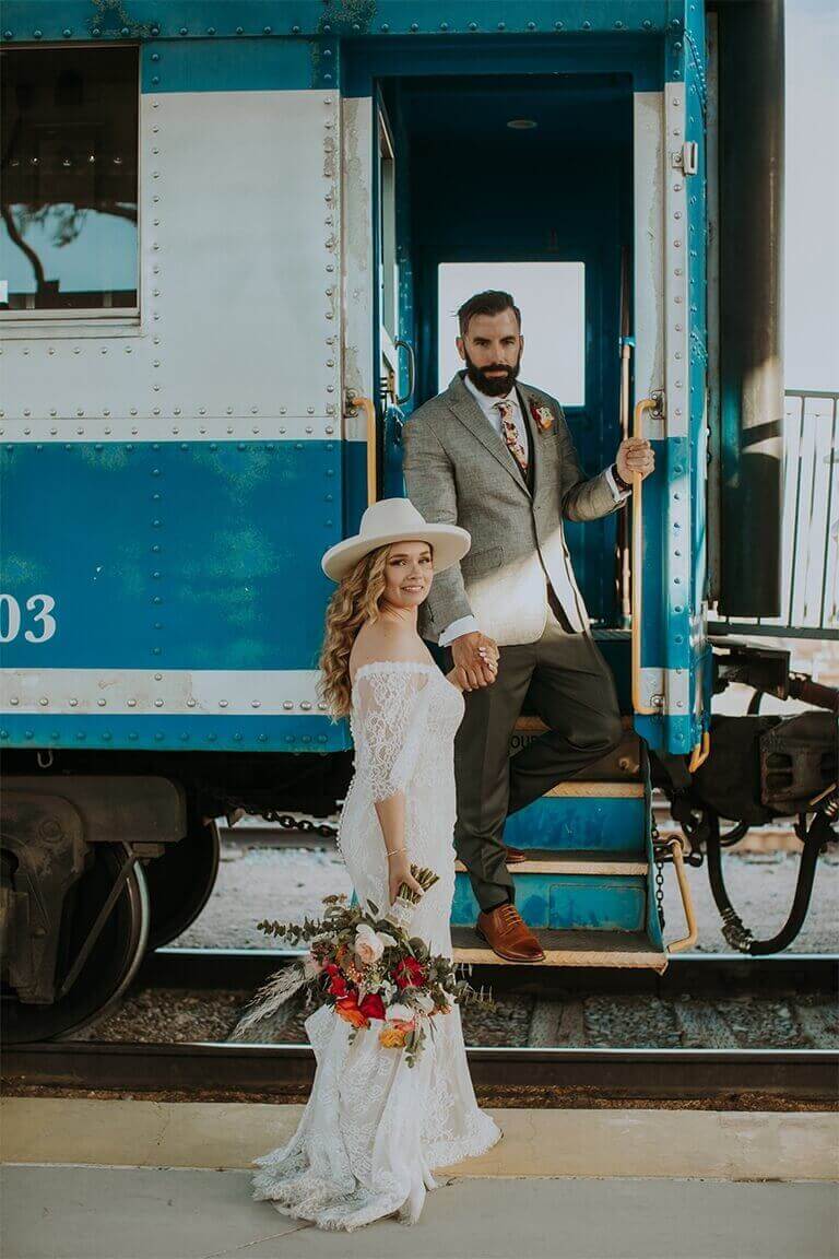 A couple poses at the entrance of a train car