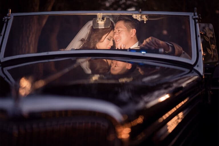 Newlyweds snuggling in the front seat of a limousine