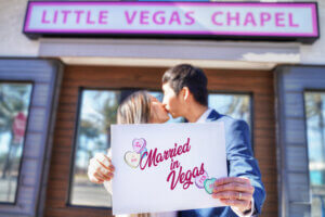 couple holding a sign and kissing