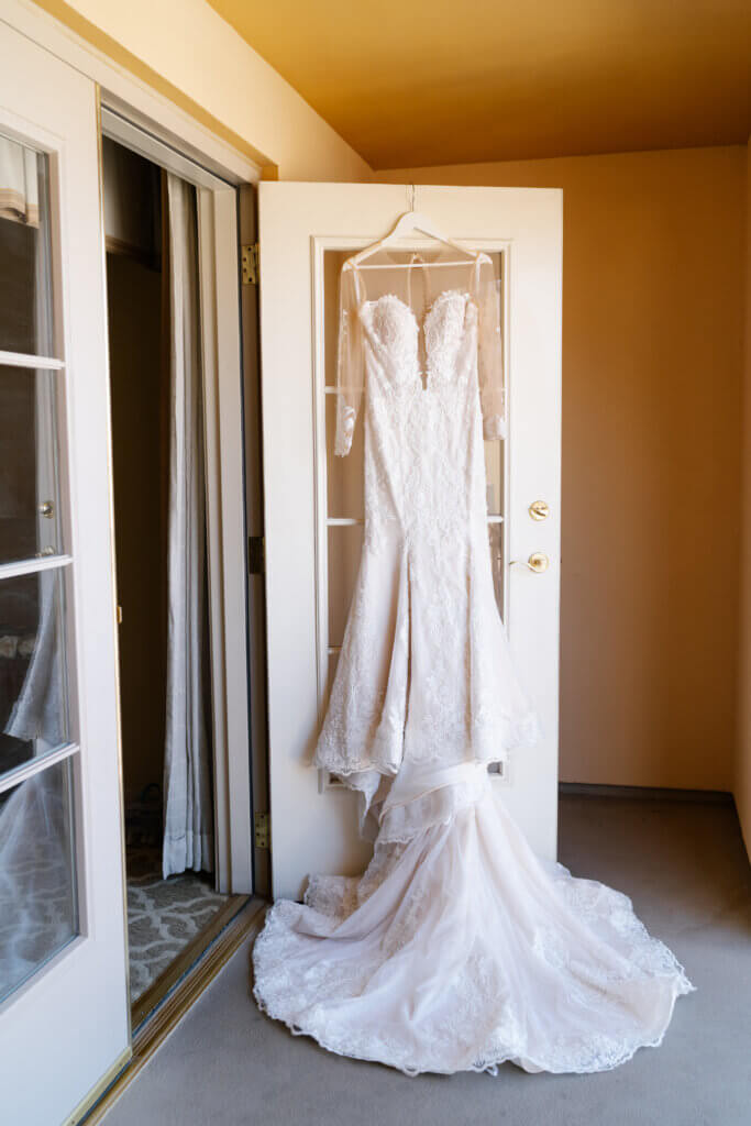 A wedding dress hanging from a door
