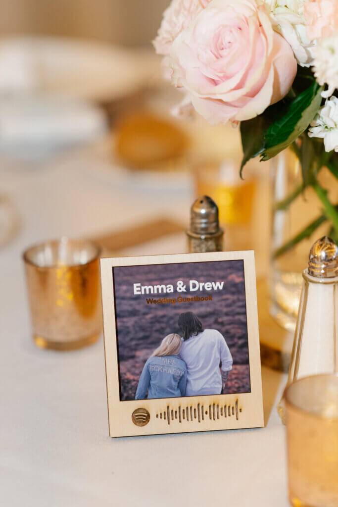a wood table placard has a scannable code for a wedding Spotify playlist