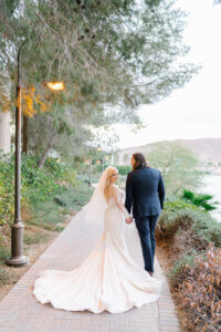bride and groom walking down a cobblestone path with a lamp post