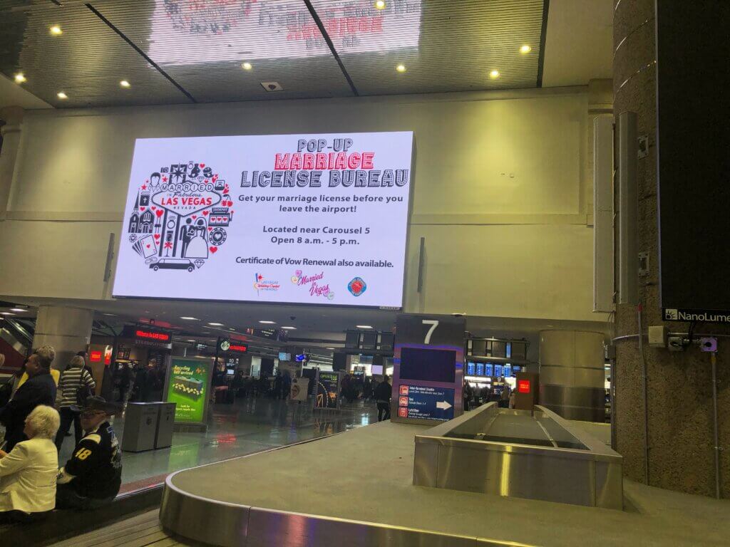 the sign over baggage claim for marriage license bureau pop-up