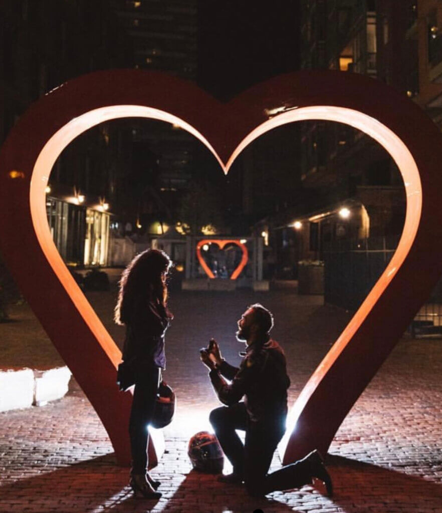 a man kneeling down in front of a woman and Big Heart to propose