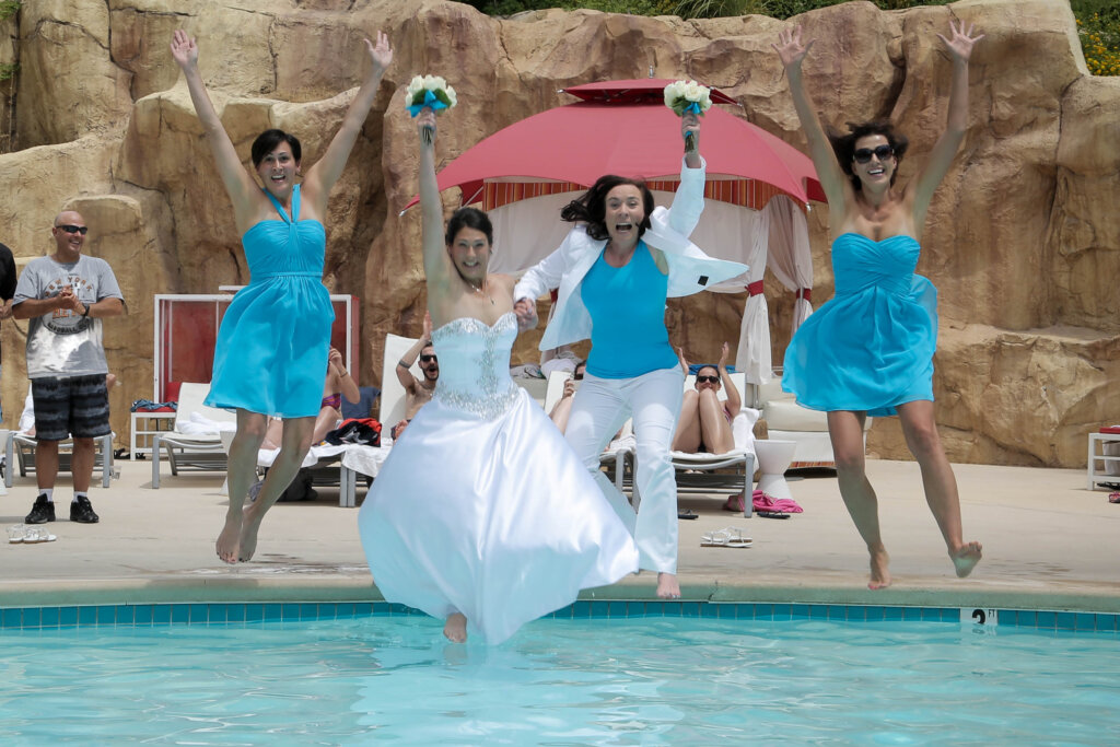 a bride and her bridesmaids jump into a pool