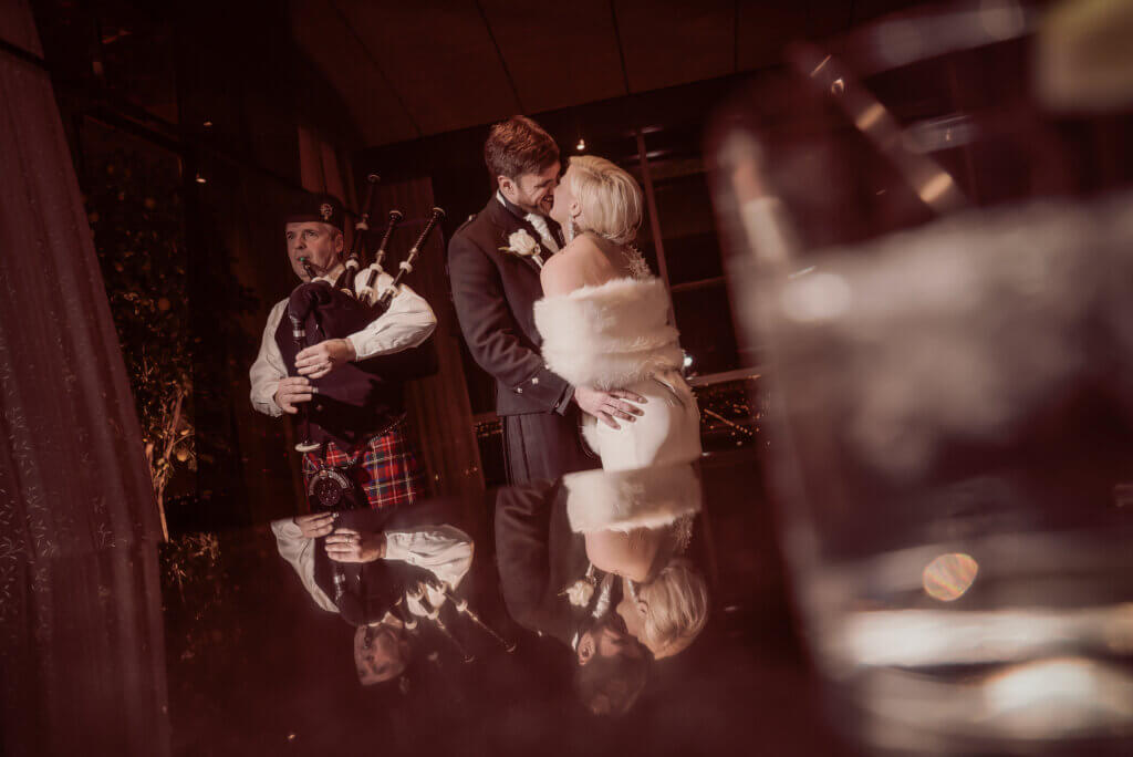 a couple dances with bagpipes in the background