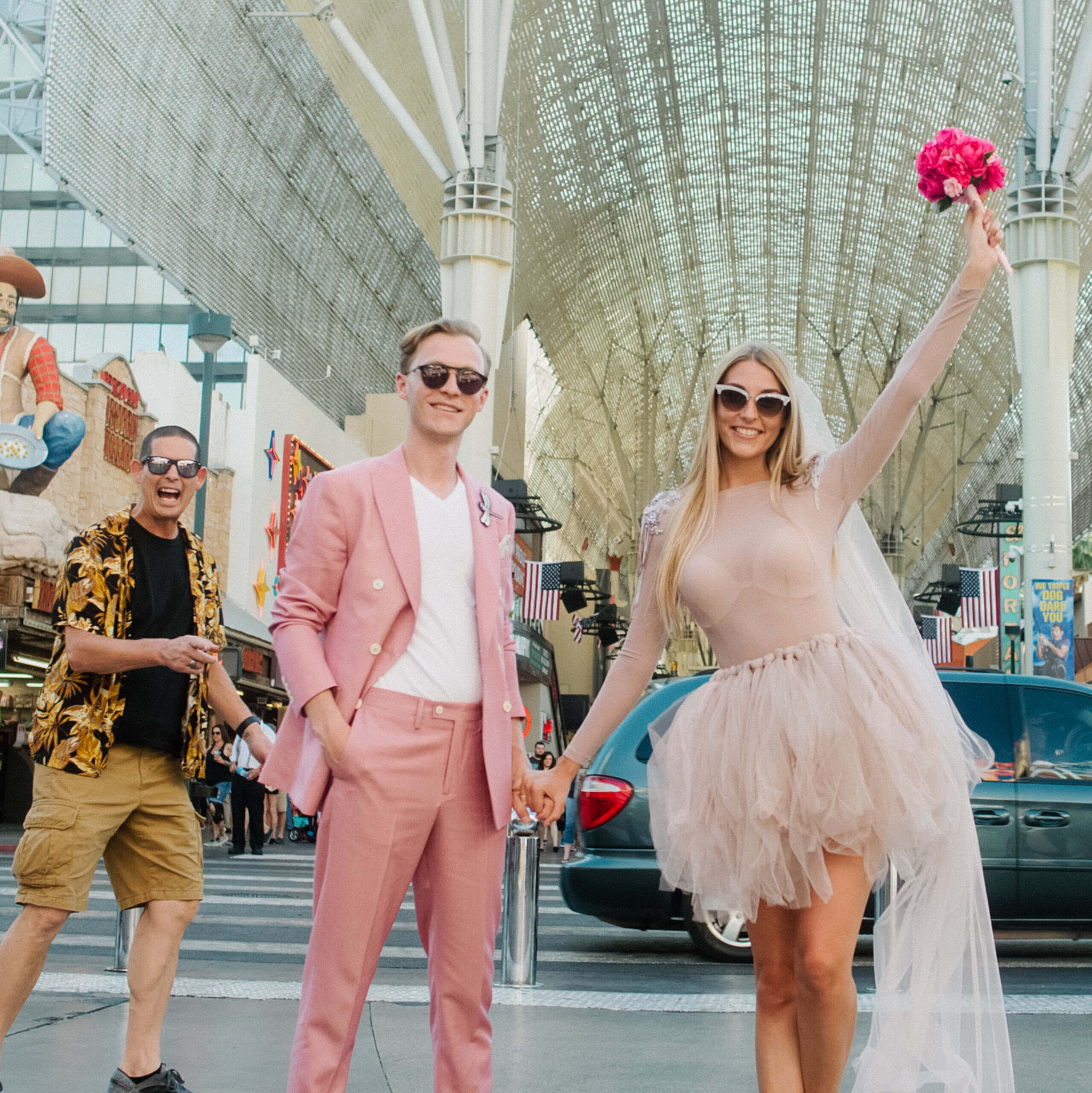 an eloped couple walks Fremont Street