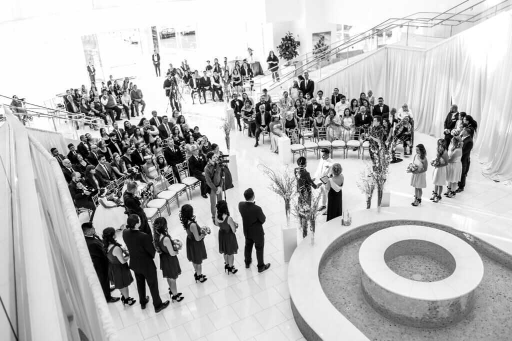 a large wedding party standing by a fountain