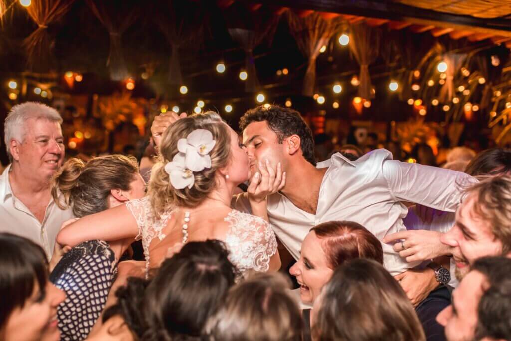 Bride and groom kissing in front of friends