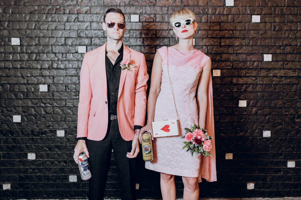 a couple in pink holding party favors