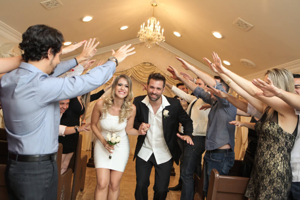 a woman and man walking through their wedding guests