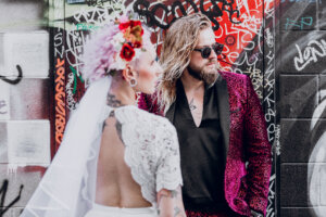 a man with blonde hair standing behind a woman in a flower veil