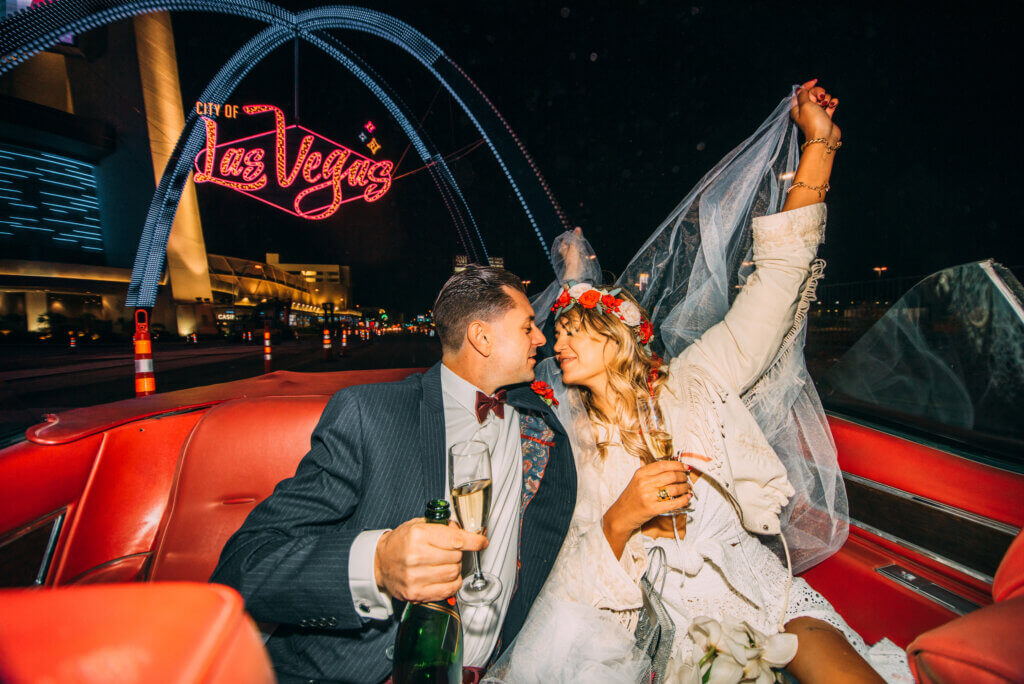 a wedding couple in a red car