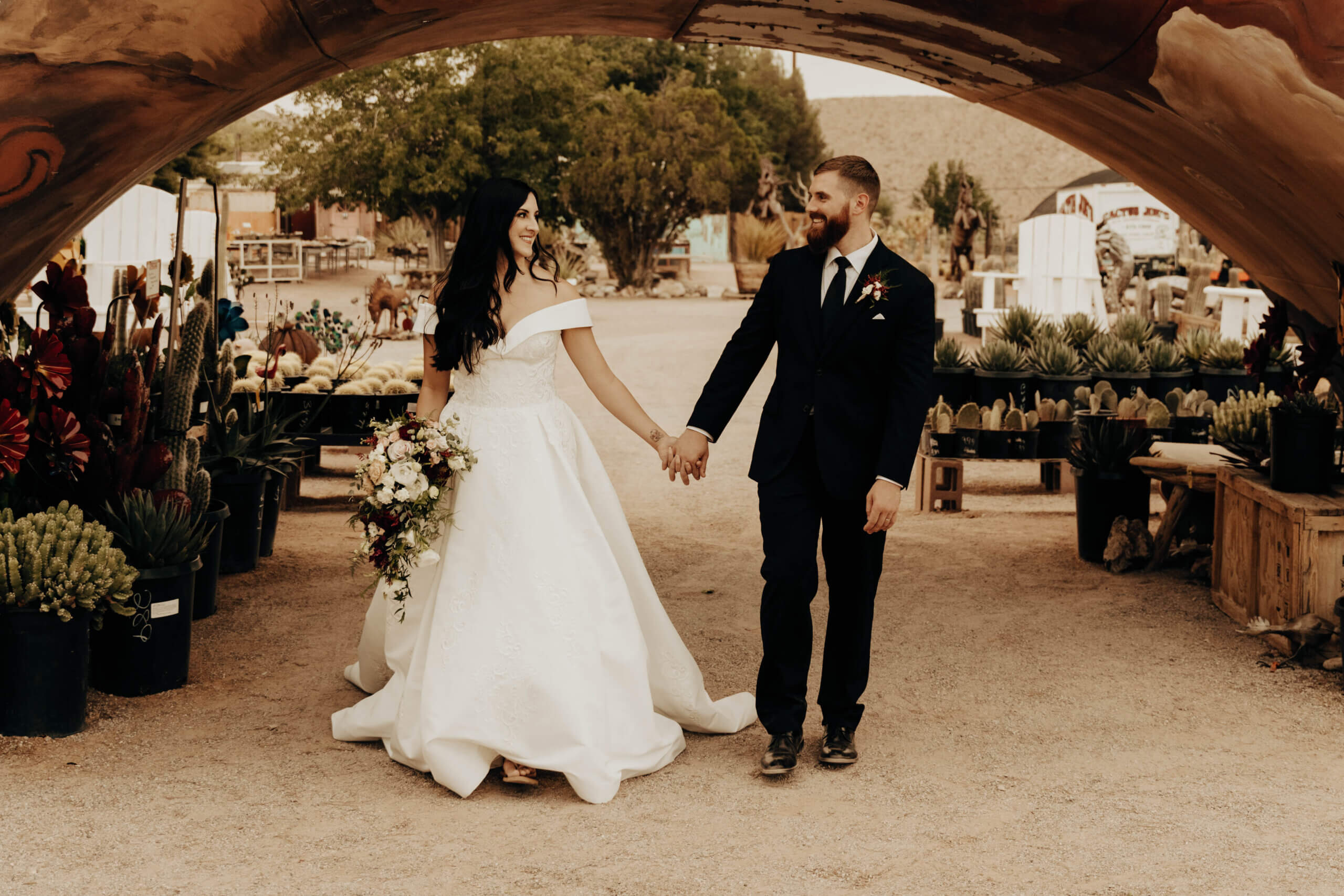 a couple walking under a wooden arch