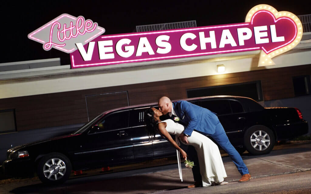 a couple kissing in front of a limo