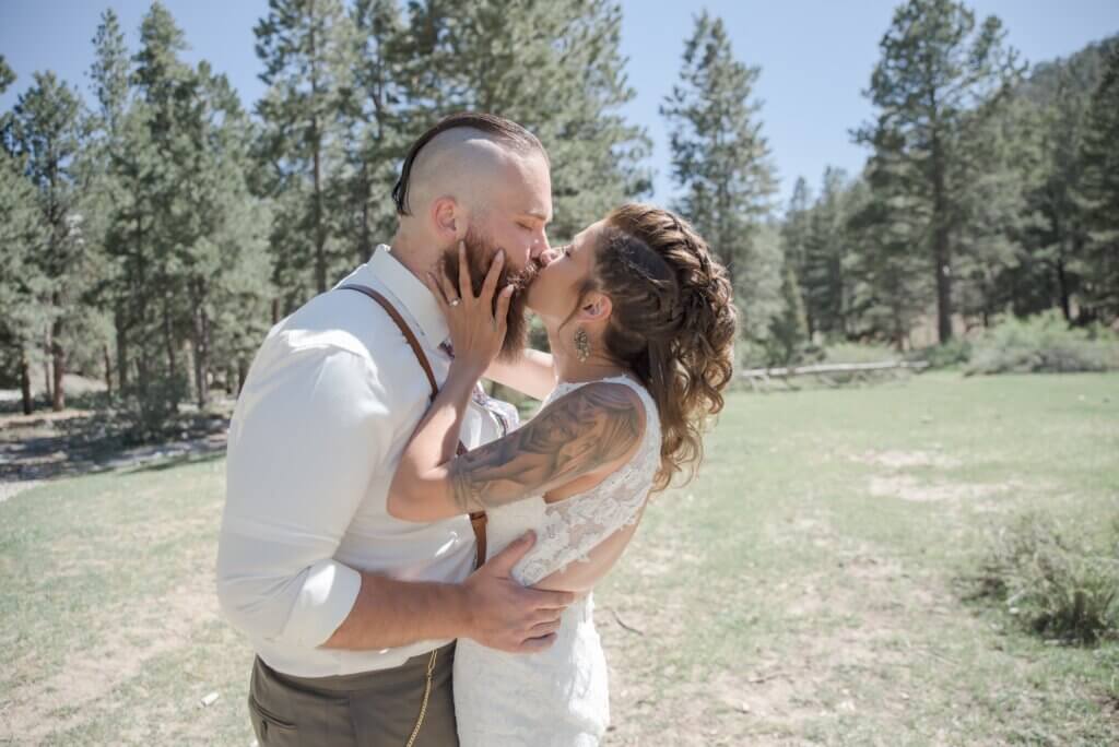 a wedding couple kissing in the forest