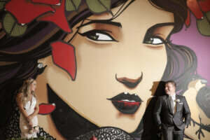 a couple standing in front of a mural