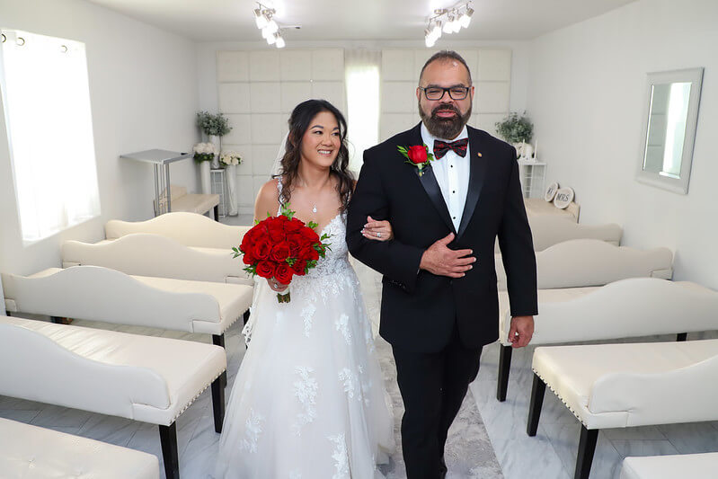 wedding couple walking down a white aisle