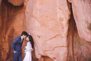 a couple next to red rocks at their wedding