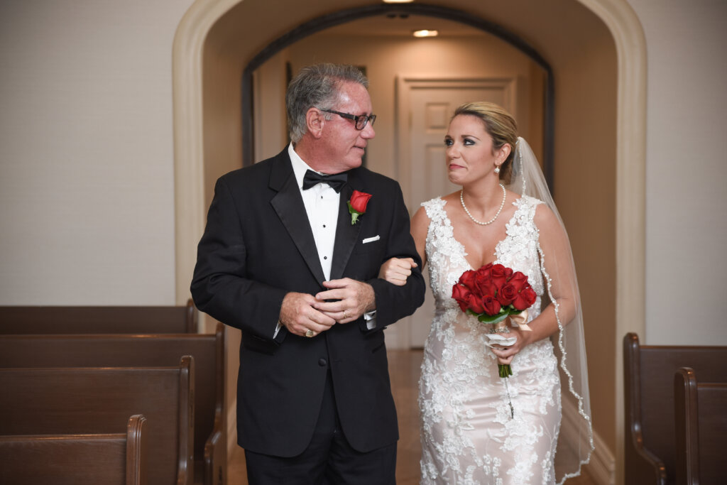 a father and daughter walking down the aisle in a chapel and crying