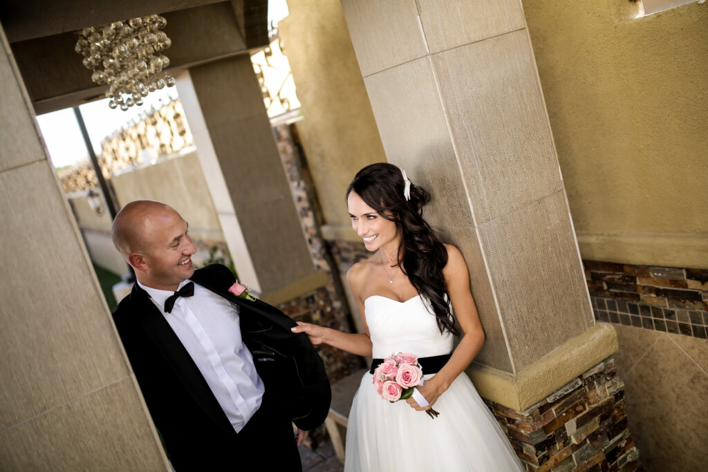 a 2026 wedding couple standing next to columns