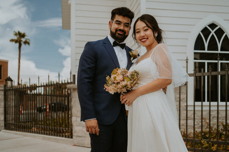 a happy wedding couple in front of a chapel