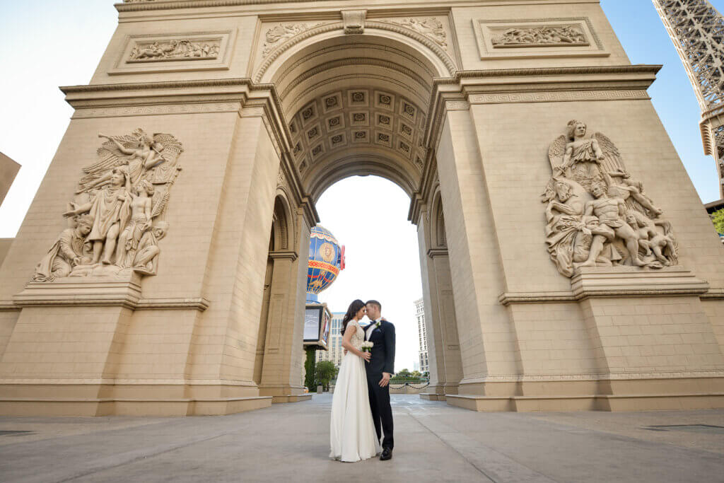 a Taurus wedding couple standing under the Arc in Vegas