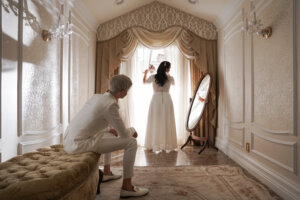 a wedding couple wearing white in a mirror room