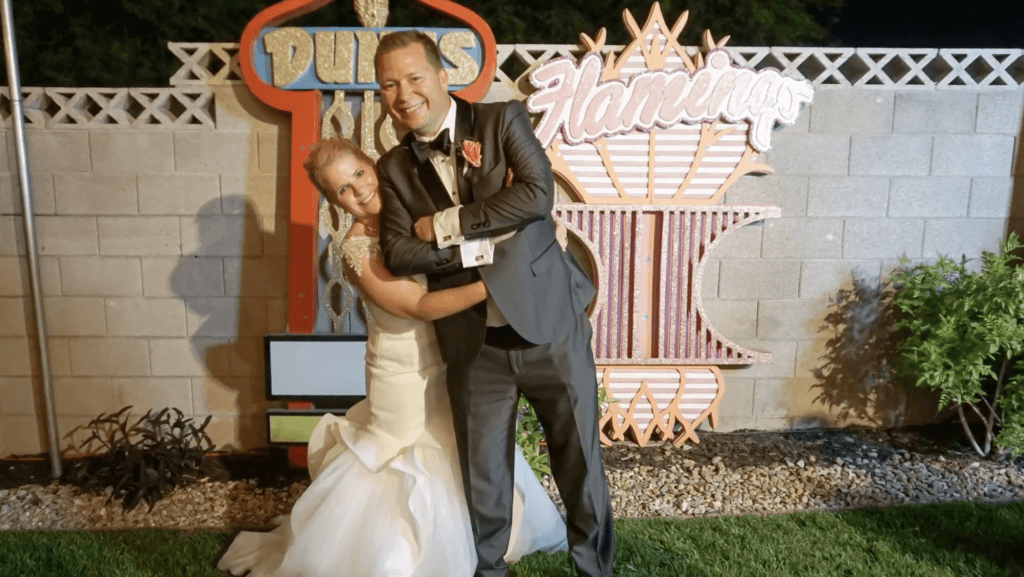 Mark and Cara next to sparkly signs on their wedding night
