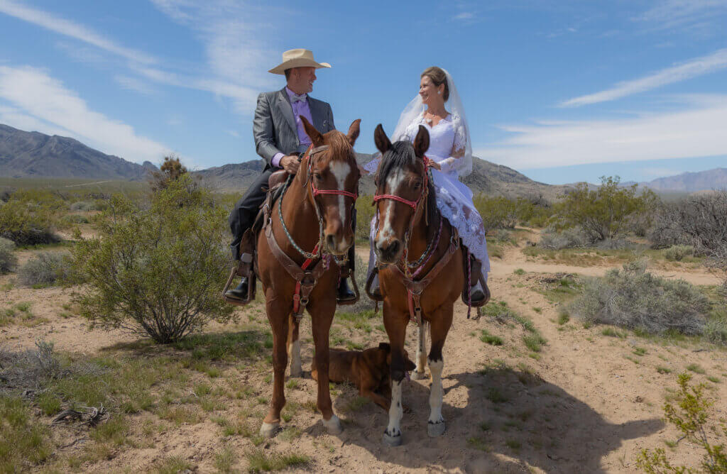 a wedding couple on horses in the desert