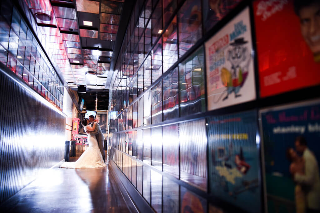 a couple kissing in a hallways with framed photographs