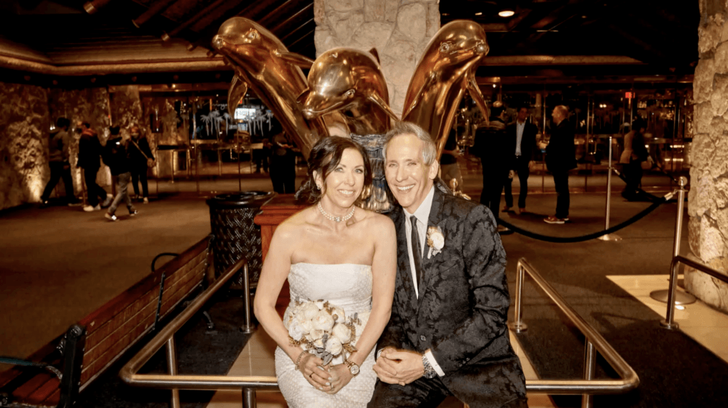a wedding couple sitting on a golden bench