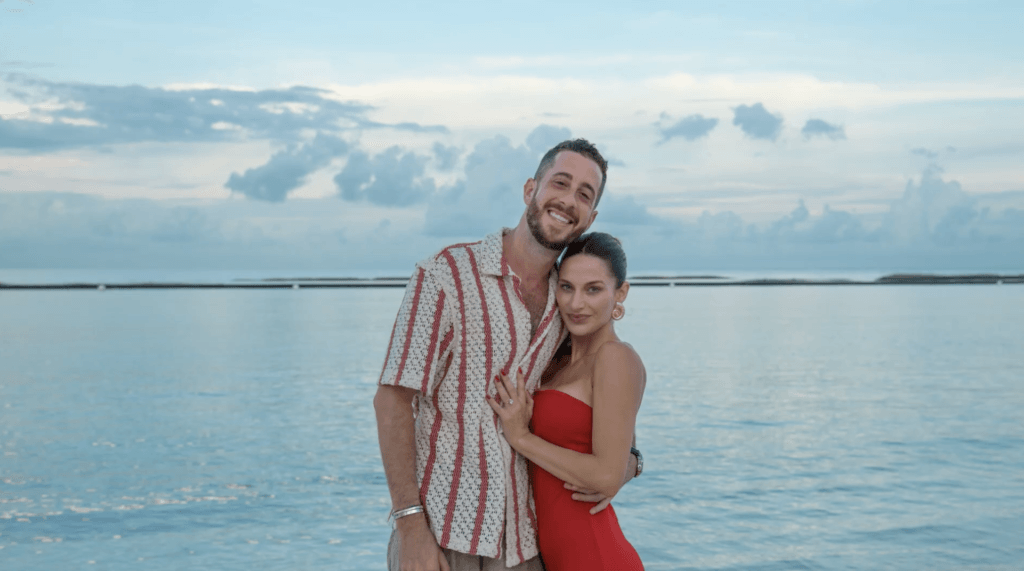 a happy couple in front of blue water
