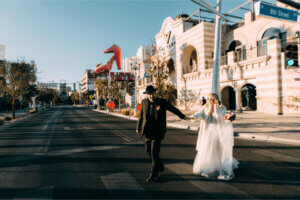 newlyweds run across 8th street at a downtown Las Vegas wedding
